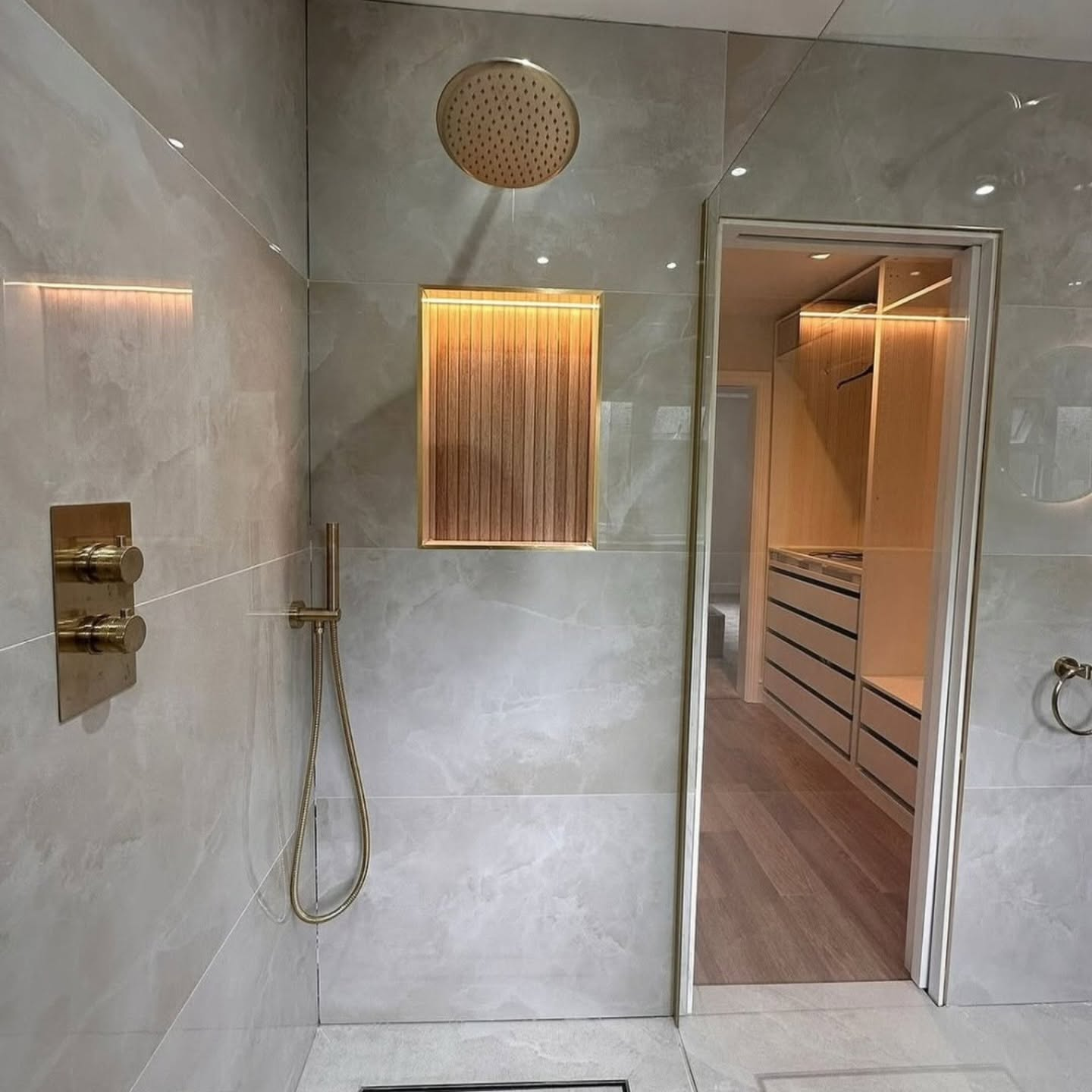 Large-format stone shower with brass rainhead
