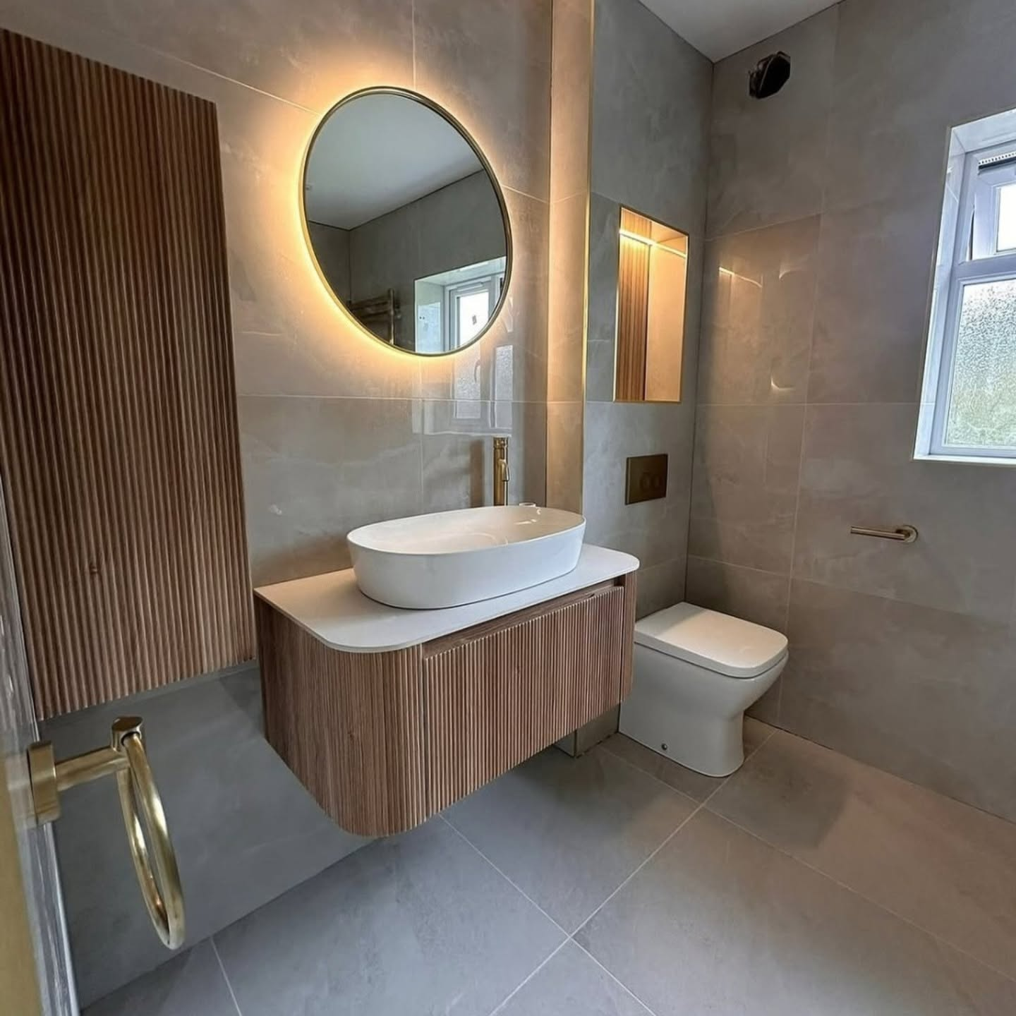 Fluted floating vanity powder room with round backlit mirror
